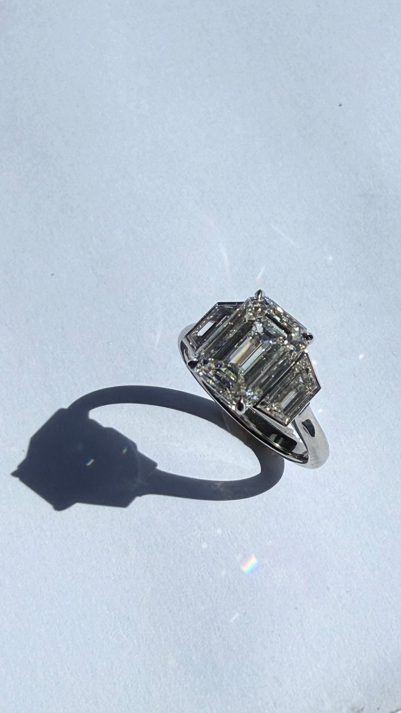 CLOSE UP OF 4CT EMERALD DIAMOND RING WITH TRAPEZOIDS