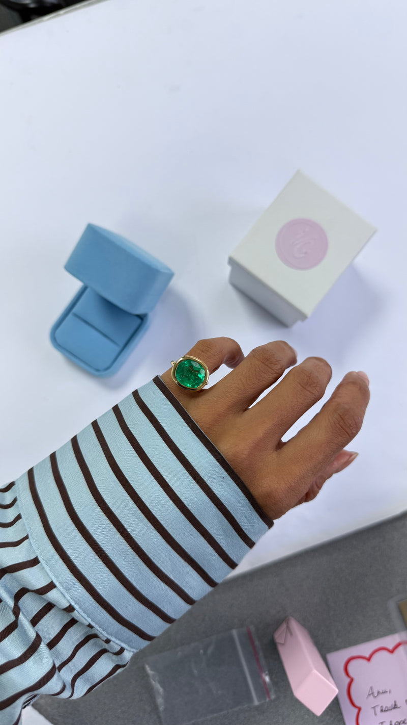 close up of big colombian emerald cushion shaped ring