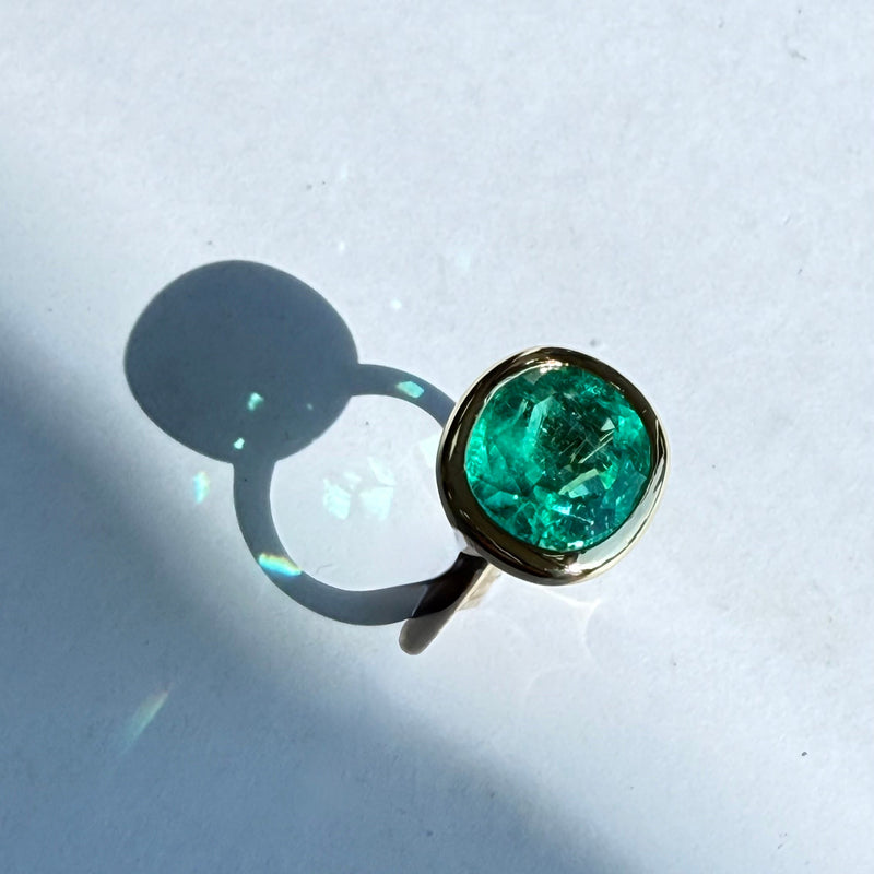 close up of big colombian emerald cushion shaped ring